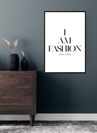 Minimalist "I AM FASHION" poster by Coco Chanel displayed above a modern wooden dresser in a stylish room.