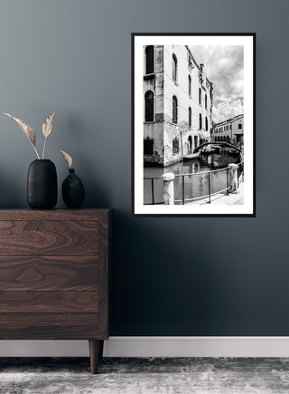 Kanal gennem by poster featuring a black-and-white canal scene hanging on a dark wall above a dresser.