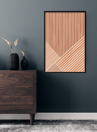Brown lines art poster with geometric pattern hanging on a dark wall above a wooden dresser in a modern living room.