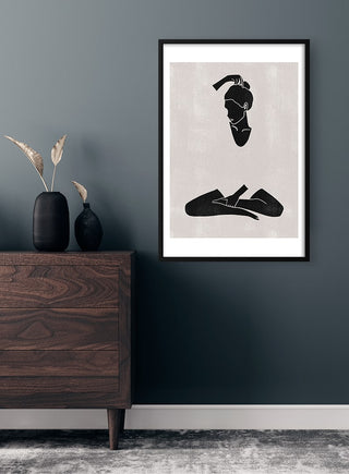 Minimalist Calm and Peaceful Woman poster in black and white, framed and displayed above a dark wooden dresser.
