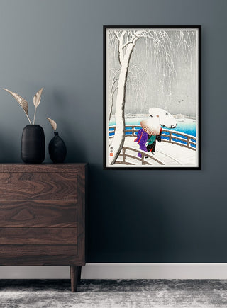 Framed print of "Two women in the snow - Yanagi Bridge" hanging on a dark wall above a wooden dresser.