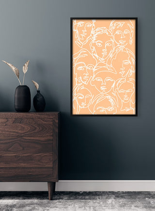 Framed Faces in White Plakat with abstract white faces on peach background, hung above a dresser in a modern room.