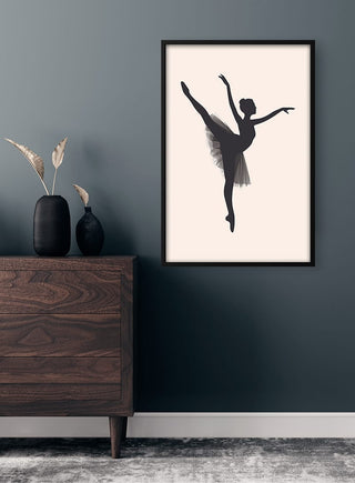 Framed Ballet Dancer Plakat hanging on a dark wall above a wooden chest with minimalist decor.