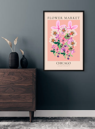 Framed Flower Market - Chicago poster with pink flowers on a blush background, displayed above a wooden dresser.