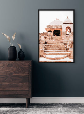 Framed Old Indian city Plakat featuring ancient stone steps and temple, displayed on a dark wall above a dresser.