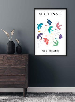 Framed Matisse Inspired Birds Decoupe Plakat with colorful abstract bird shapes, displayed on a dark wall above a dresser.