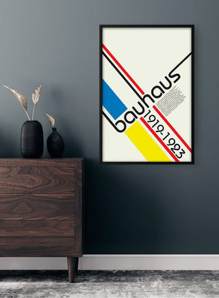 Framed Bauhaus Lines Plakat with geometric lines and primary colors, hung on a dark wall above a wooden dresser.