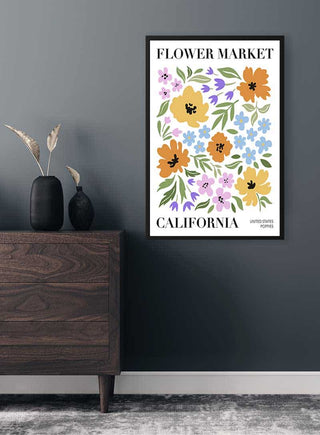 Framed print of colorful floral illustration labeled "Flower Market California" hanging on a dark wall.