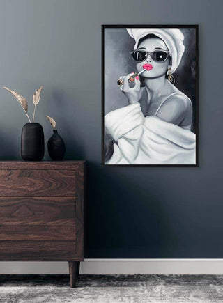 Framed vintage-style art of a glamorous woman in sunglasses, towel turban, and lipstick on a modern living room wall.