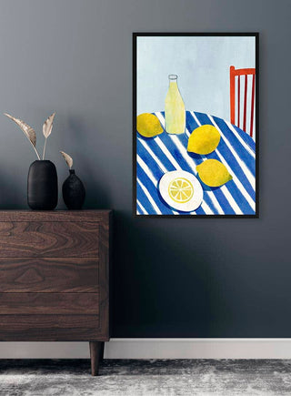 Art print of lemons, a bottle, and a red chair on a striped tablecloth, by Henry Rivers, displayed above dresser.
