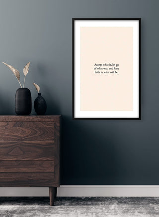 Minimalist "Have Faith" quote poster in a black frame, displayed above a wooden dresser in a modern room.