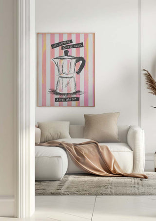 Cozy living room with a white sofa and wall art of a moka pot reading "A hug in a cup" on pink stripes.