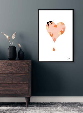 Framed "Sara Sonne - Stay" art print with abstract heart on wall above wooden dresser in modern room.