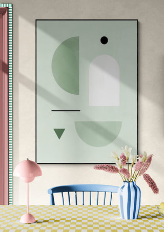 Abstract wall art in soft pastel colors, with a pink lamp and vase on a patterned table in a cozy room.