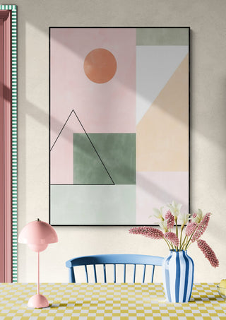 Wall art featuring pastel geometric shapes and minimalist lines above a dining table with decor accents.