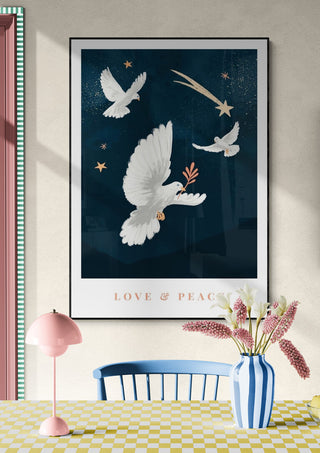 Framed "Love & Peace - Goed Blauw" print with doves, stars, and a comet above a pastel-colored table setting.
