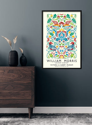 William Morris birds poster with colorful floral and bird motifs, framed and hung on a modern dark wall.