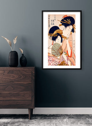 Framed poster of traditional Japanese women in kimonos displayed on a dark wall above a wooden dresser.