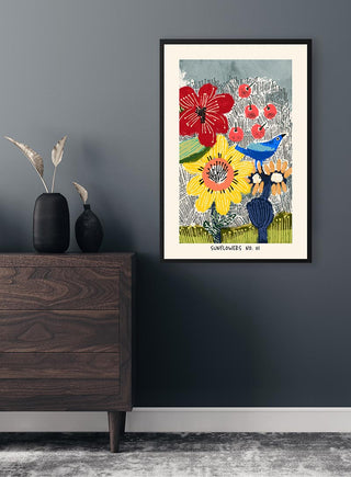 Flowerbomb Sunflowers No. 01 Plakat framed on a dark wall above a wooden dresser with black vases.
