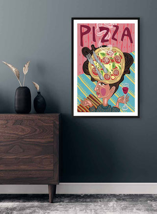 Framed "På Hovedet Pizza" art print by Nina Broen on a dark wall above a wooden dresser with vases.