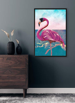 Framed art of a pink flamingo at the beach, displayed above a wooden drawer in a modern room.