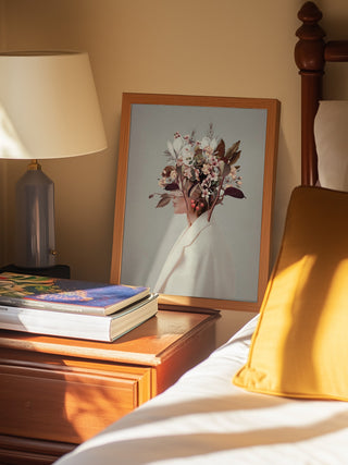Framed "I Fell In Love With Fall Because of You" art by Frank Moth leaning on a bedside table.