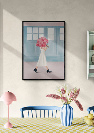 Framed art print of a woman holding pink flowers, displayed above a dining table with matching decor.