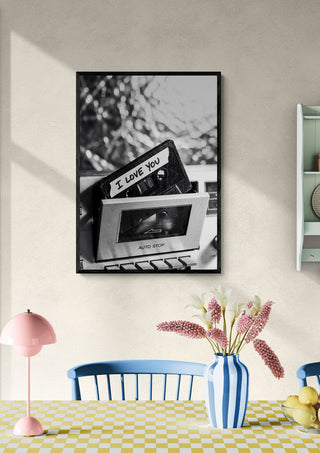 Framed photo of a hand holding an "I Love You" cassette displayed in a cozy dining room.