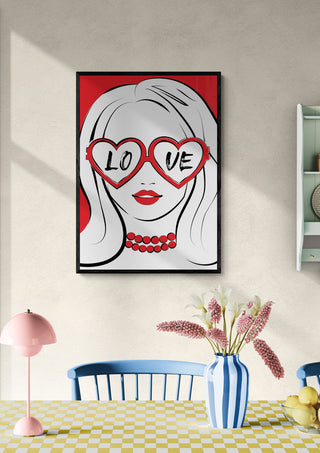 Framed pop art of a woman with heart-shaped "LOVE" glasses, displayed above a dining table.