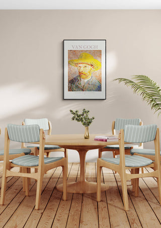 Framed Van Gogh Self Portrait hanging above a round dining table with four chairs in a cozy room.