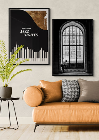 Framed "A lonely man - Massimo Della Latta" art above a tan sofa in a modern living room setting.