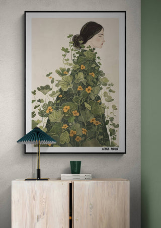 Framed "Floral Symphony - Elara Monet" artwork featuring a woman entwined with green vines and orange flowers.